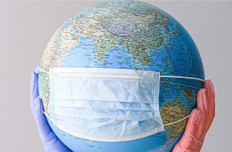 photo - gloved hands hold up a globe with a mask fitted to it