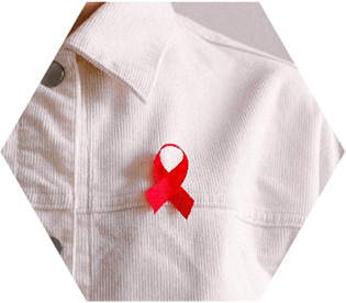 photo - closeup of someone wearing a red AIDS awareness ribbon