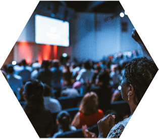 photo - a crowd looks towards a screen at a presentation